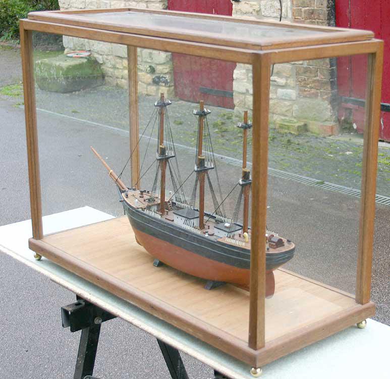 Wooden sailing ship in glass case
